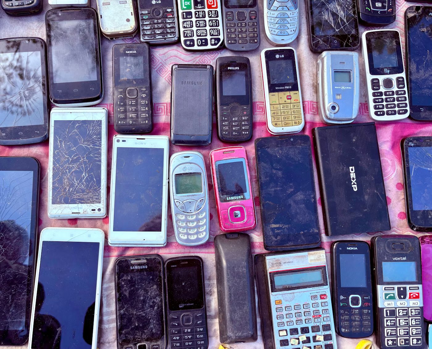 A collection of old mobile phones and devices waiting to be recycled